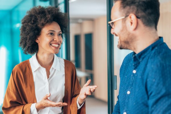 Two young business persons talking in the office.